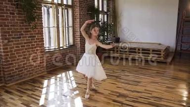 年轻的芭蕾舞演员穿着白色连衣裙和芭蕾舞鞋表演芭蕾舞元素。 有魅力的舞者表演元素